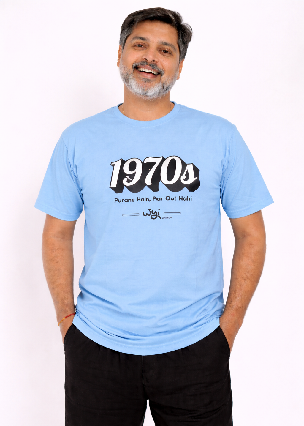 Man wearing a WYI light blue t-shirt with '1970s' design on a white background