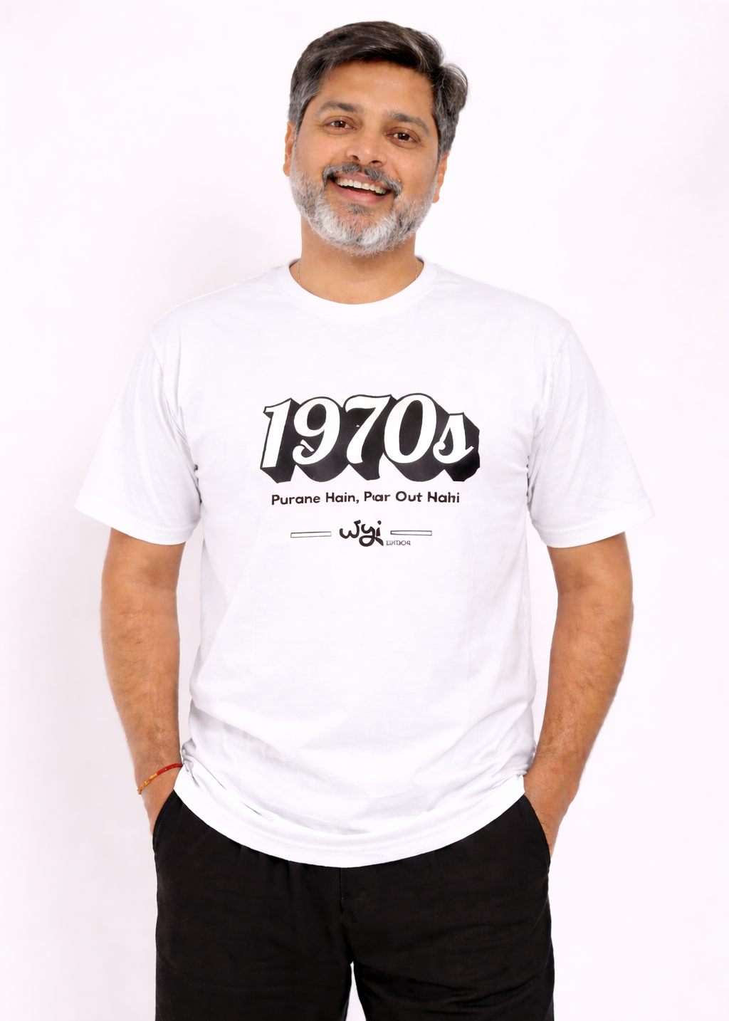 Man wearing a wyi white t-shirt with '1970s' text and black pants on a white background