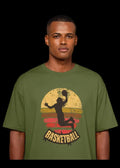 Man wearing a green t-shirt with a basketball graphic design on a gray background