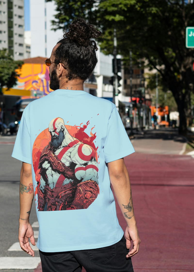 Person wearing a light blue t-shirt with a colorful graphic design on the back, walking on a city street.