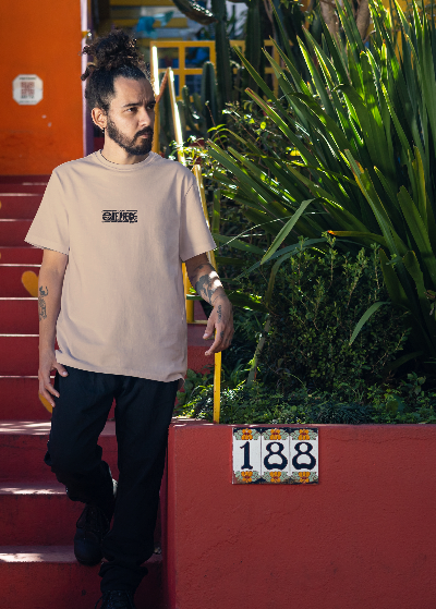 Man walking up a red staircase with heart shapes, surrounded by green plants and colorful walls.