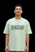 Male wearing a WYI sage green t-shirt with 'BLATANCY' graphic design on a black background
