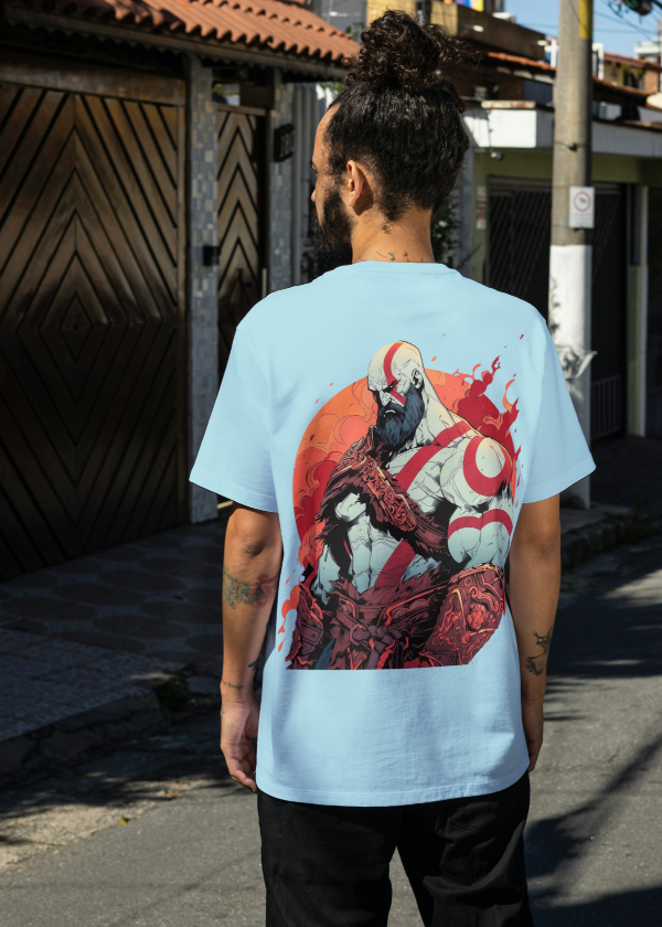 Person wearing a light blue t-shirt with a graphic design on a street.