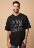 Male wearing a WYI black oversized t-shirt with graphic design in an indoor setting